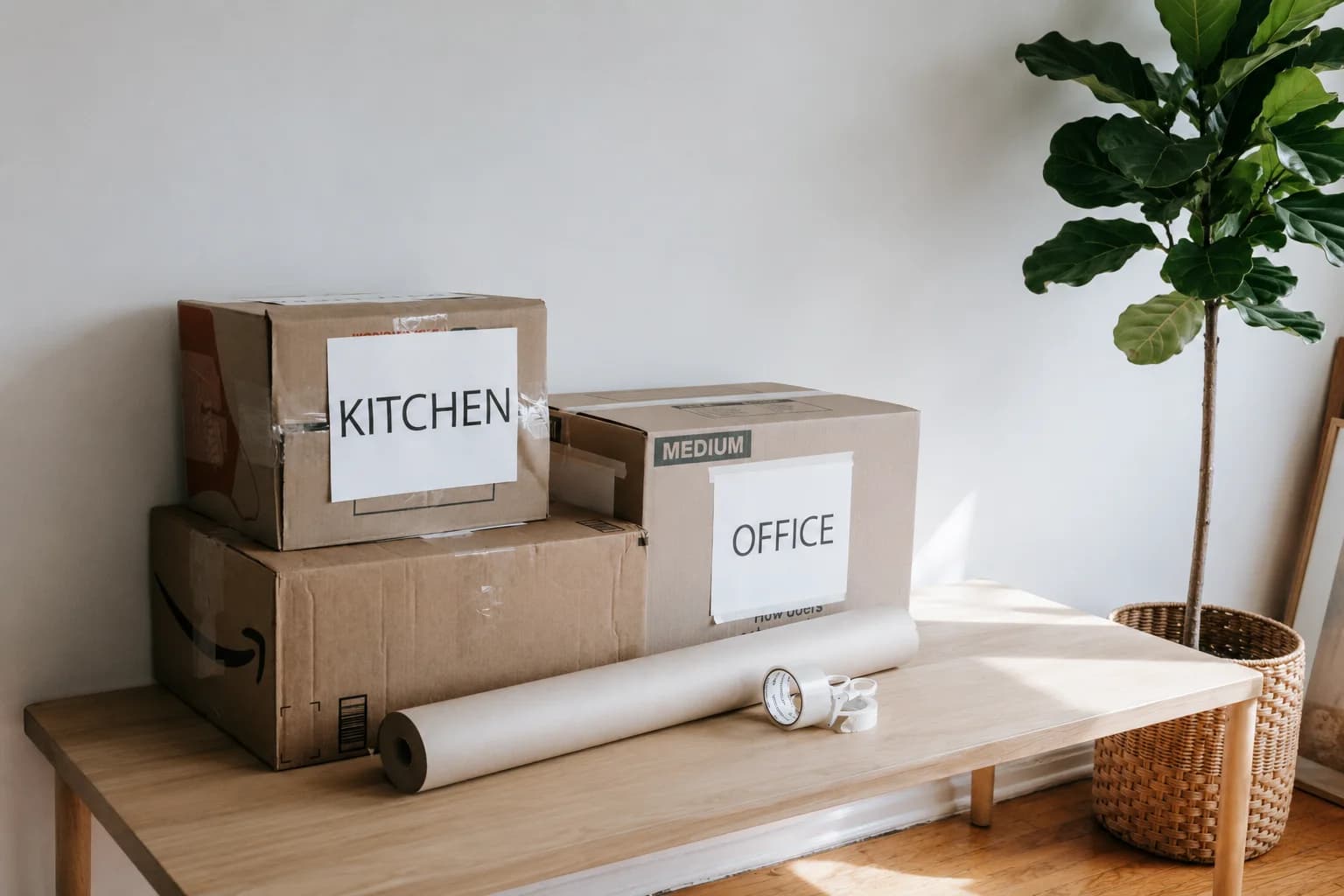 Moving boxes labelled for kitchen and office in a bright home interior